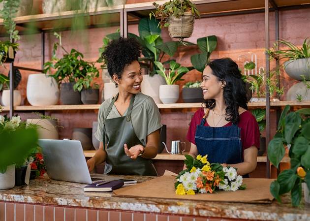 Two happy smiling women working at a florist shop
